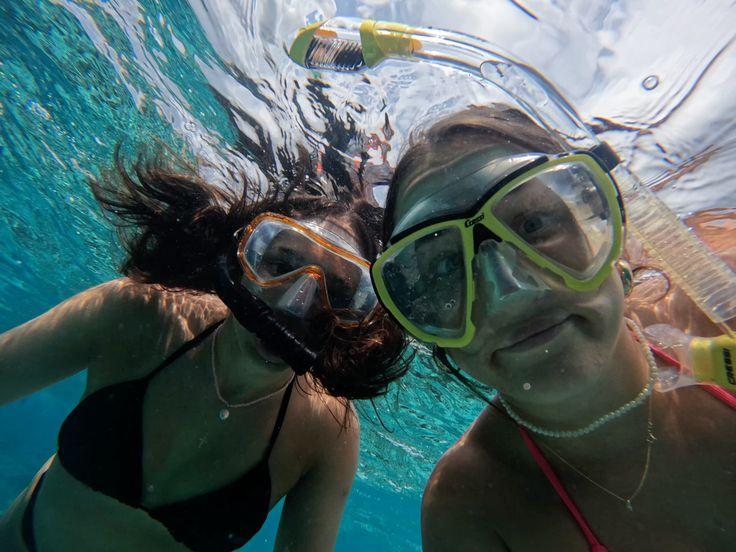 Two snorkelers exploring a vibrant coral reef with colorful fish in Hiriketiya