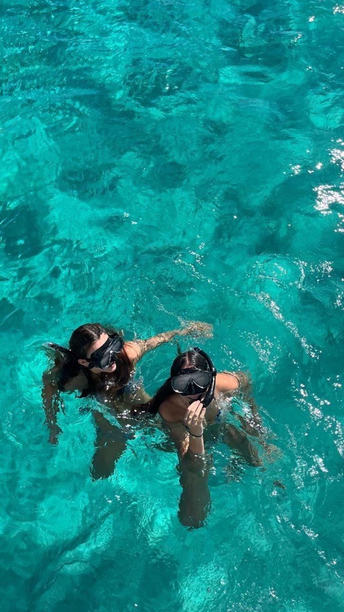 Snorkeler swimming over a vibrant coral reef with colorful fish